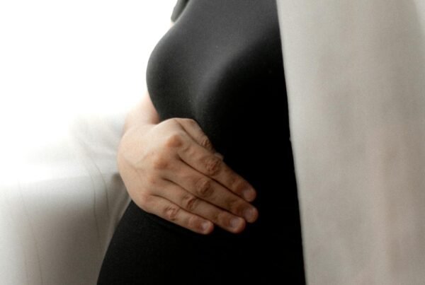 Donna in gravidanza alla finestra, luce delicata