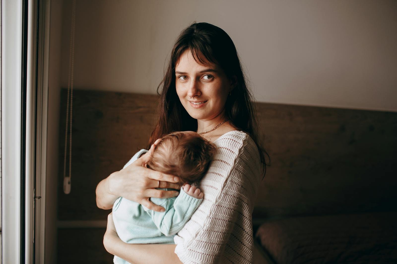 Mamma con il suo neonato in una camera dai toni caldi