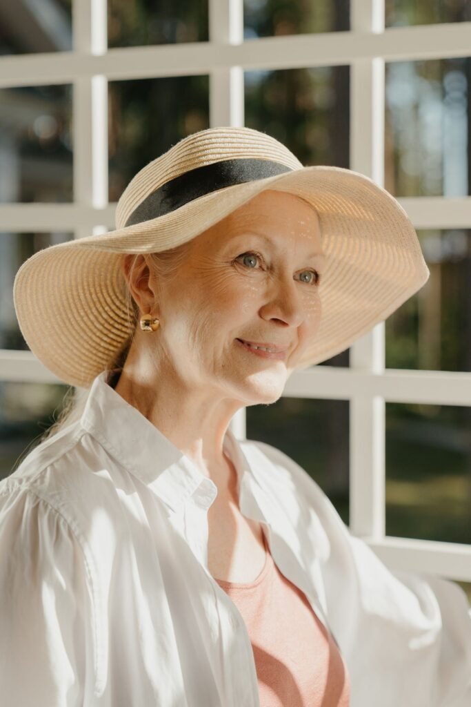 Donna matura serena con cappello di paglia, luce naturale
